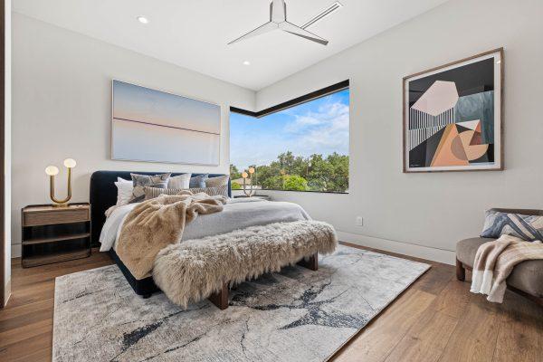 Zbranek Holt LakeLBJ Modern Luxury Lakehouse Bedroom Corner Window View Plush Bedding Modern Artwork