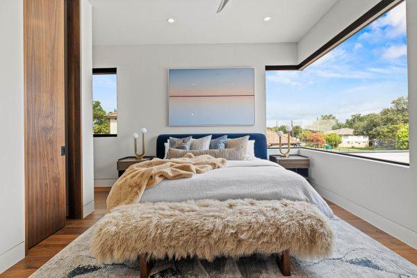 Zbranek Holt LakeLBJ Modern Luxury Lakehouse Bedroom Panoramic Windows Plush Bedding Cozy Ambiance
