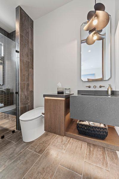 Zbranek Holt LakeLBJ Modern Luxury Lakehouse Guest Bathroom Textured Tile Shower Floating Vanity Modern Lighting