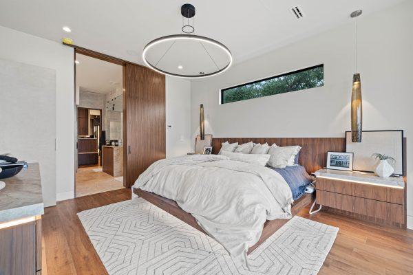 Zbranek Holt LakeLBJ Modern Luxury Lakehouse Primary Bedroom Suite Open Layout Modern Lighting Wood Finishes