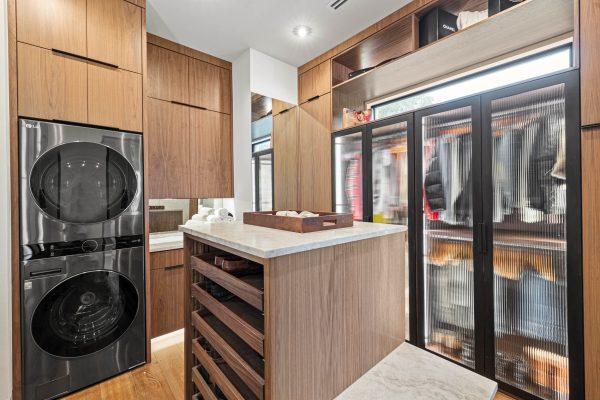 Zbranek Holt LakeLBJ Modern Luxury Lakehouse Primary Suite Closet Built in Laundry Island Cabinetry
