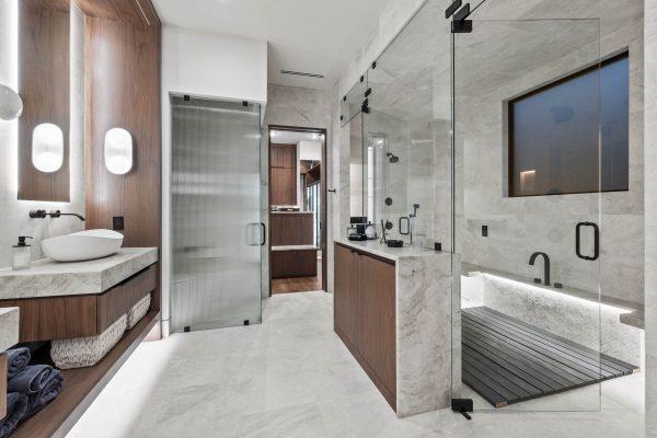 Zbranek Holt LakeLBJ Modern Luxury Lakehouse Spa Primary Bathroom Frosted Glass Doors Tiled Shower Soaking Tub