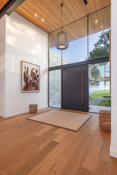 Modern Organic Lakehouse Foyer Black Door Wood Floor Ceiling Zbranek and Holt Custom Homes