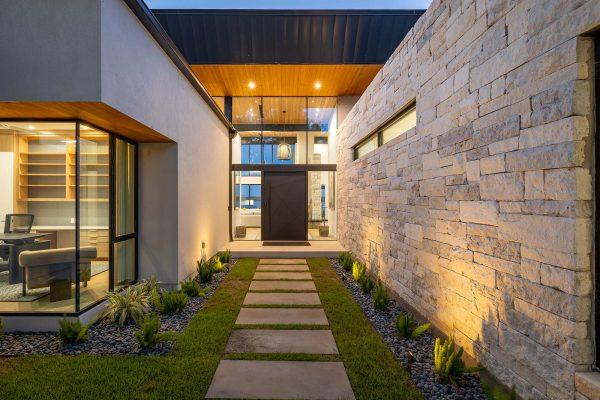 Modern Organic Lakehouse Front Entry Stone Wall Wood Ceiling Glass Doors Zbranek and Holt Custom Homes