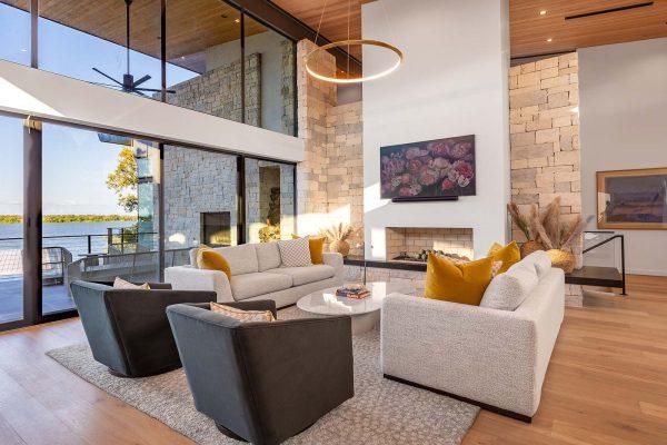 Modern Organic Lakehouse Living Room Stone Fireplace Floor to Ceiling Glass Zbranek and Holt Custom Homes