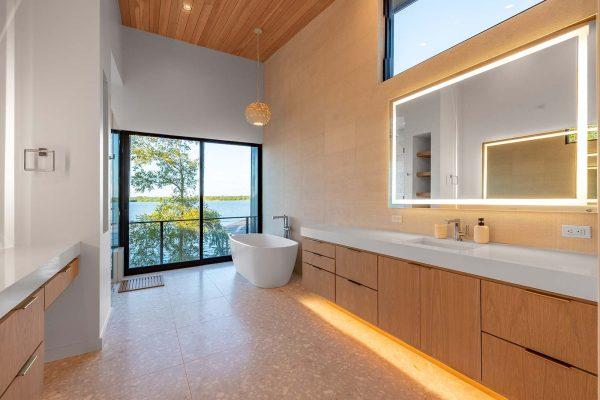 Modern Organic Lakehouse Master Bathroom Freestanding Tub Floor to Ceiling Windows Water View Zbranek and Holt Custom Homes